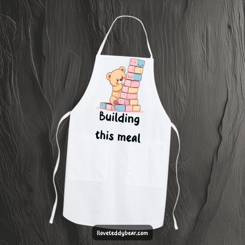 Funny teddy bear apron showing a bear attempting to build a precarious tower of blocks, a culinary challenge in humor.