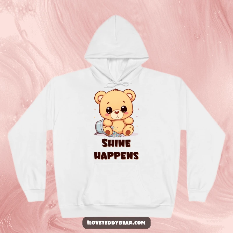 Funny hoodie with a teddy bear wide-eyed, spilling a bucket of glitter, offering warmth and a humorous, sparkly design.
