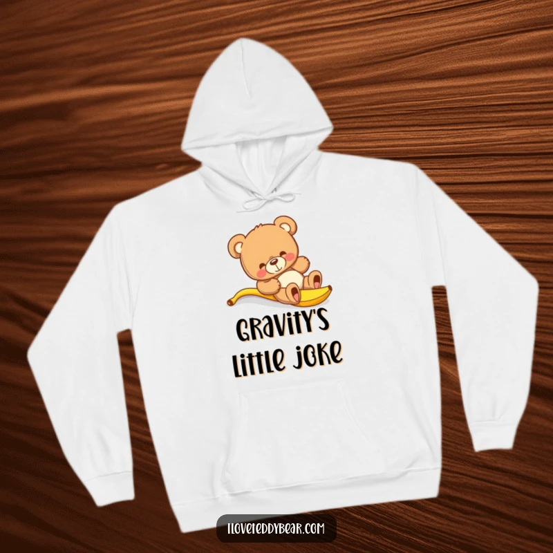 Funny teddy bear hoodie showing a bear comically losing its balance after stepping on a banana peel, creating a humorous scene.
