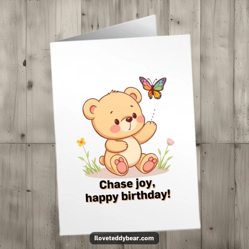 Funny Free Printable Birthday Card: A fluffy teddy bear playfully chases a vibrant, bouncing butterfly through a meadow.