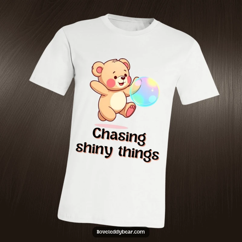 Funny Teddy Bear T-Shirt: Adorable teddy bear jumping joyfully, chasing a large, iridescent bubble in mid-air.